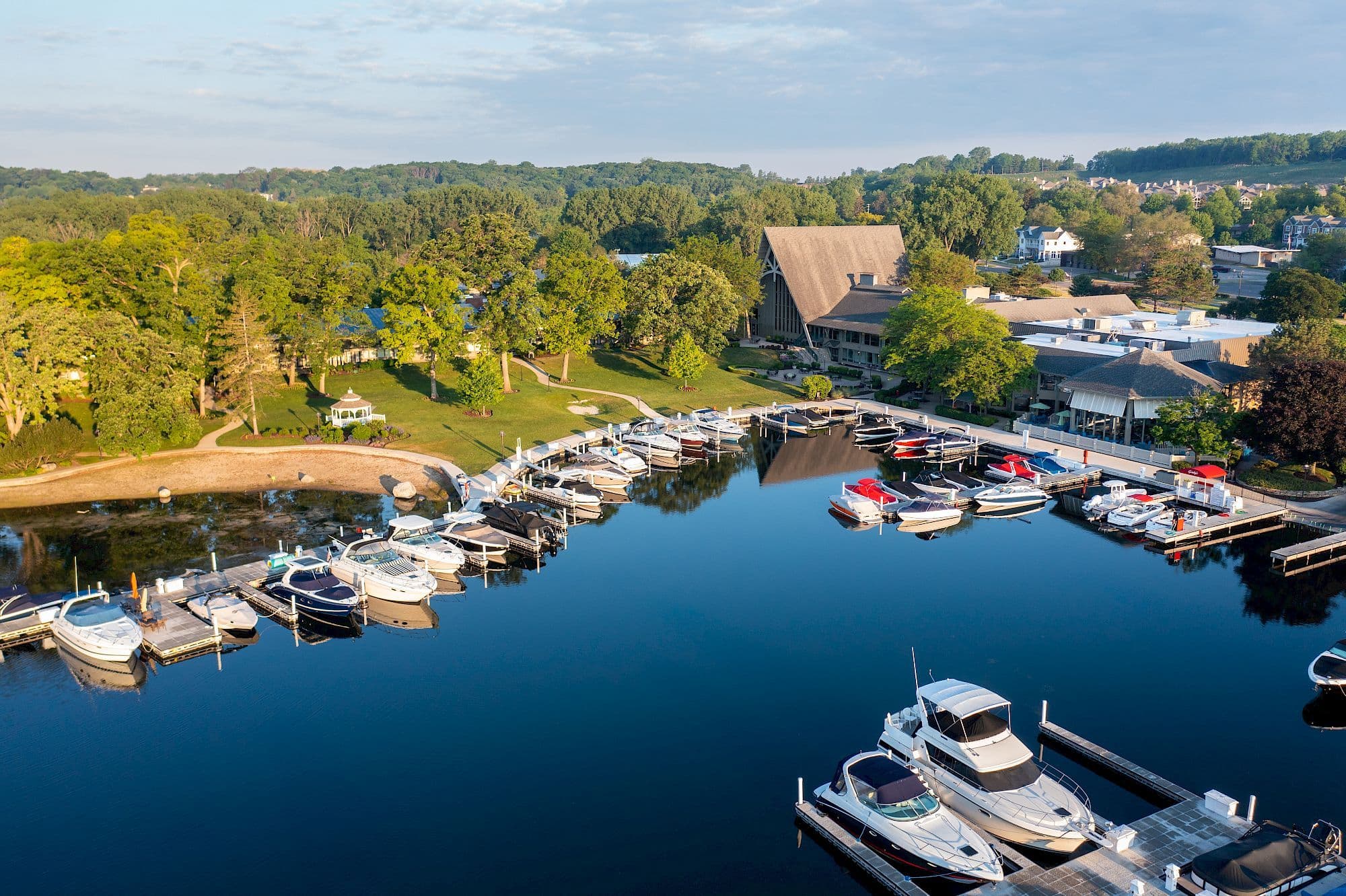 The Abbey Resort, Lake Geneva Marina full of boats with nearby beach, aerial view