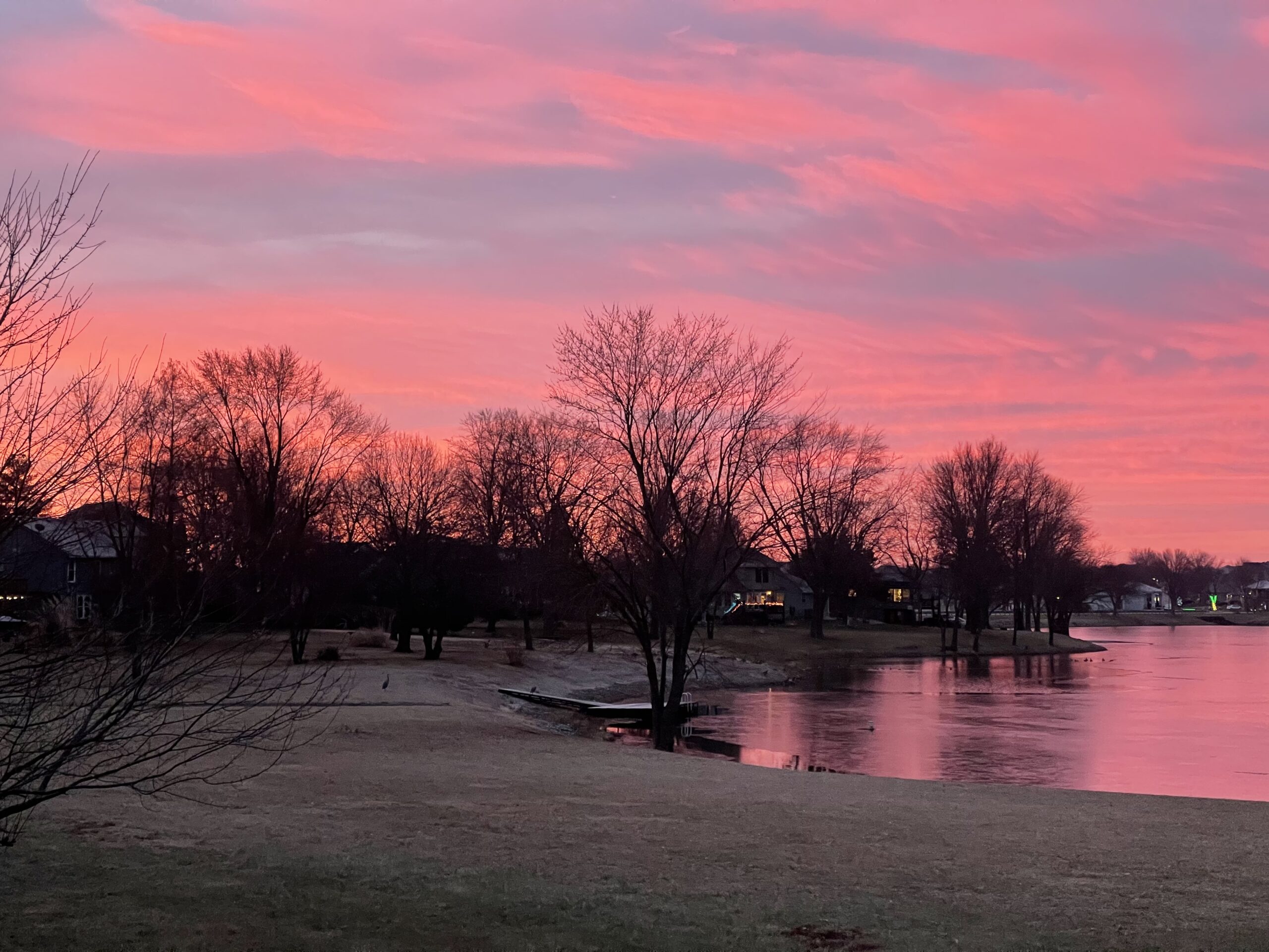 Pink sunset with winter views of a lake