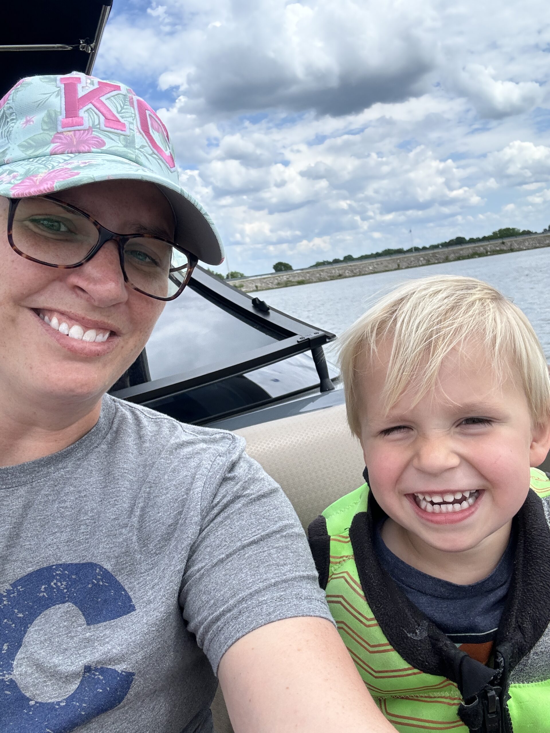 Mom and son on a boat with lake in the background