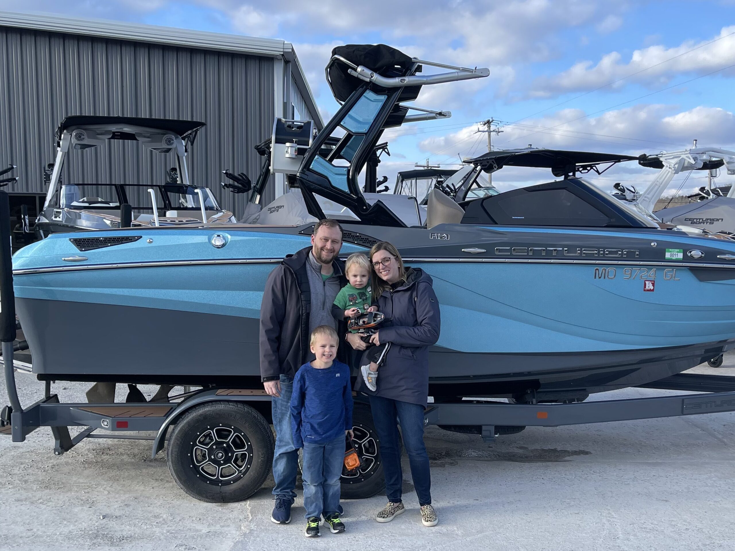 Family with two kids standing in front of Centurion boat