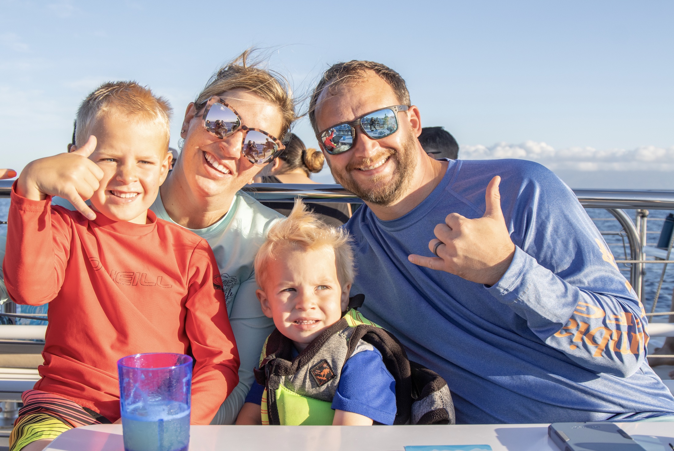 Family with two young boys on a Boat in Maui giving Hang Loose Sign