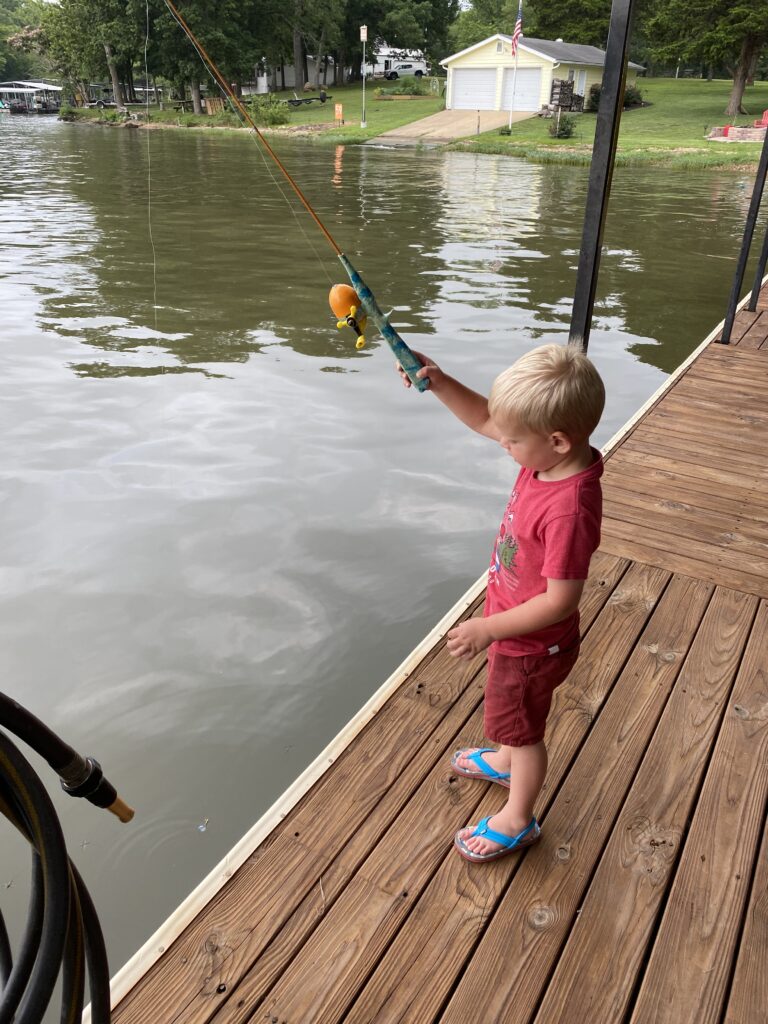 Young boy in red shirt on a dock fishing