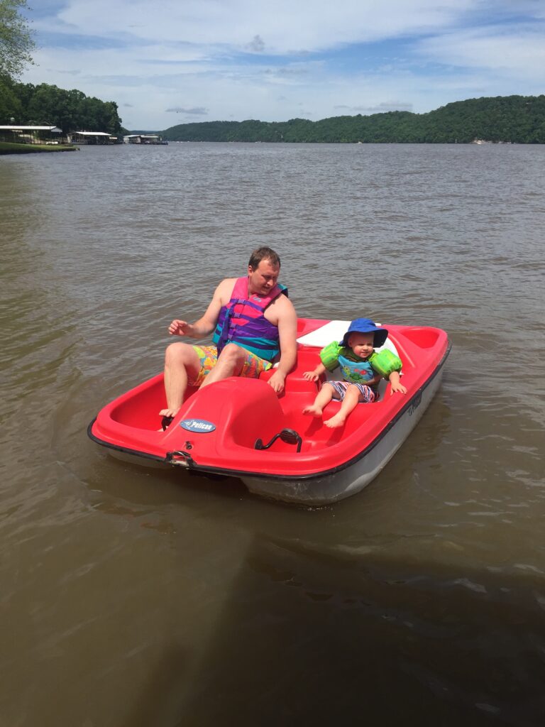 Dad and Son on a Paddle Boat at the Lake