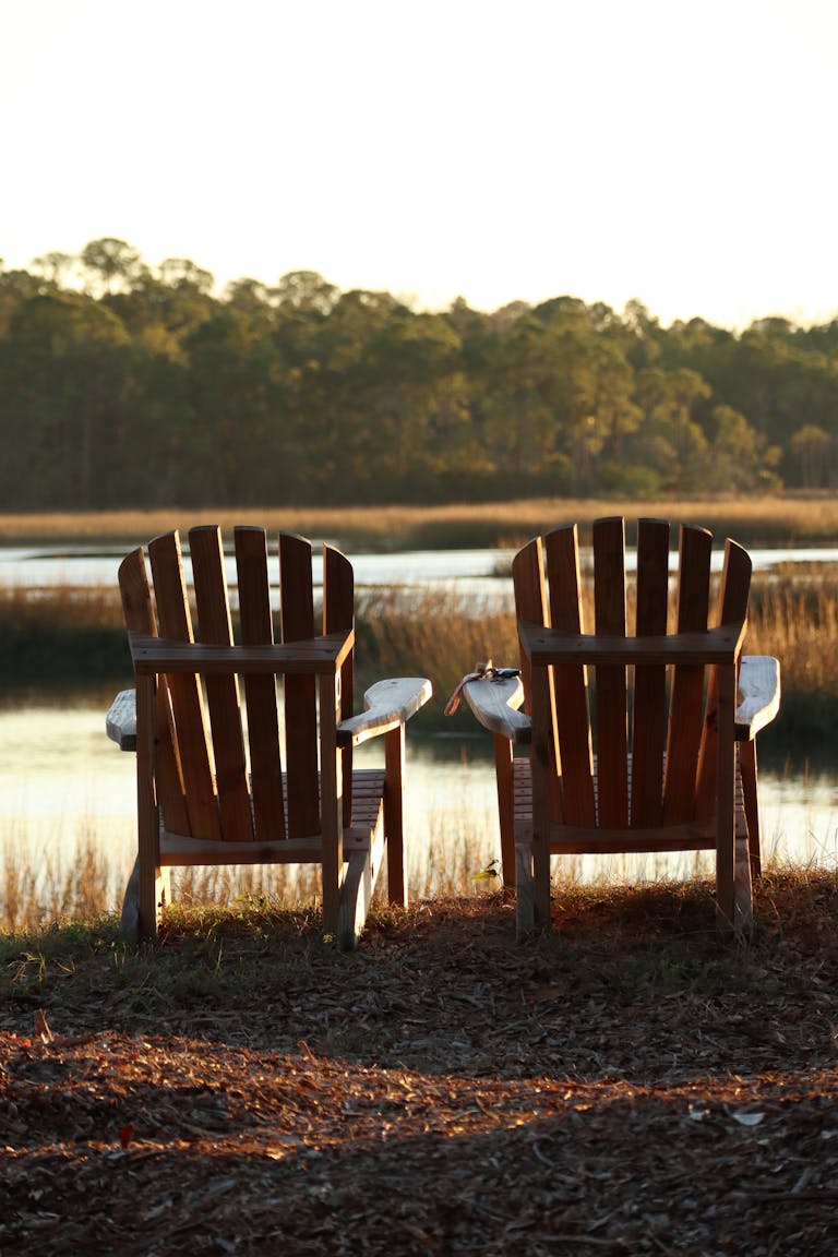 2 Adirondeck chairs in front of a Lake