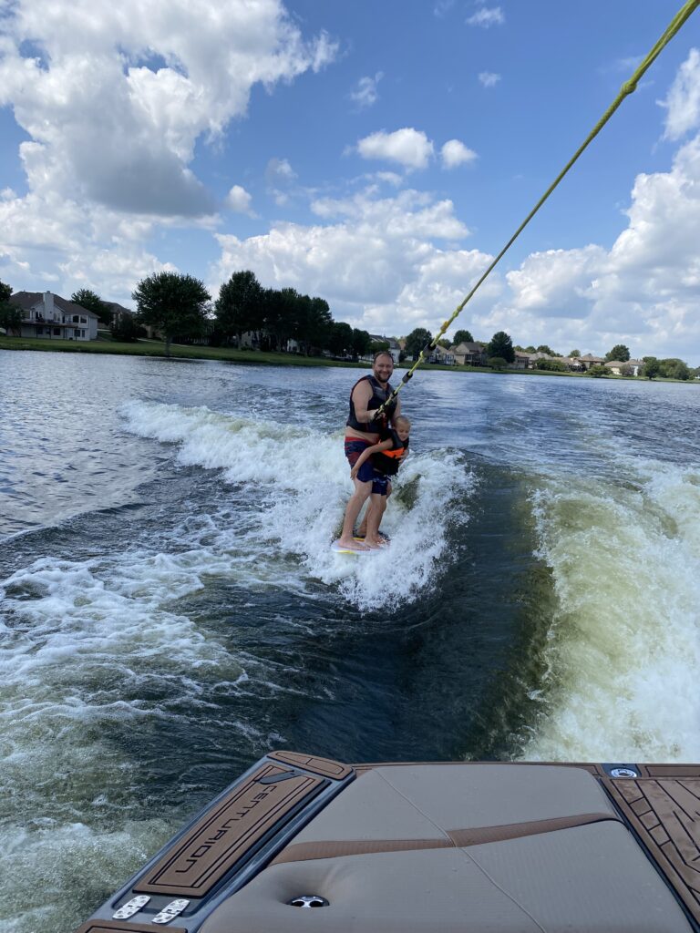 Dad and son wake surfing behind a boat