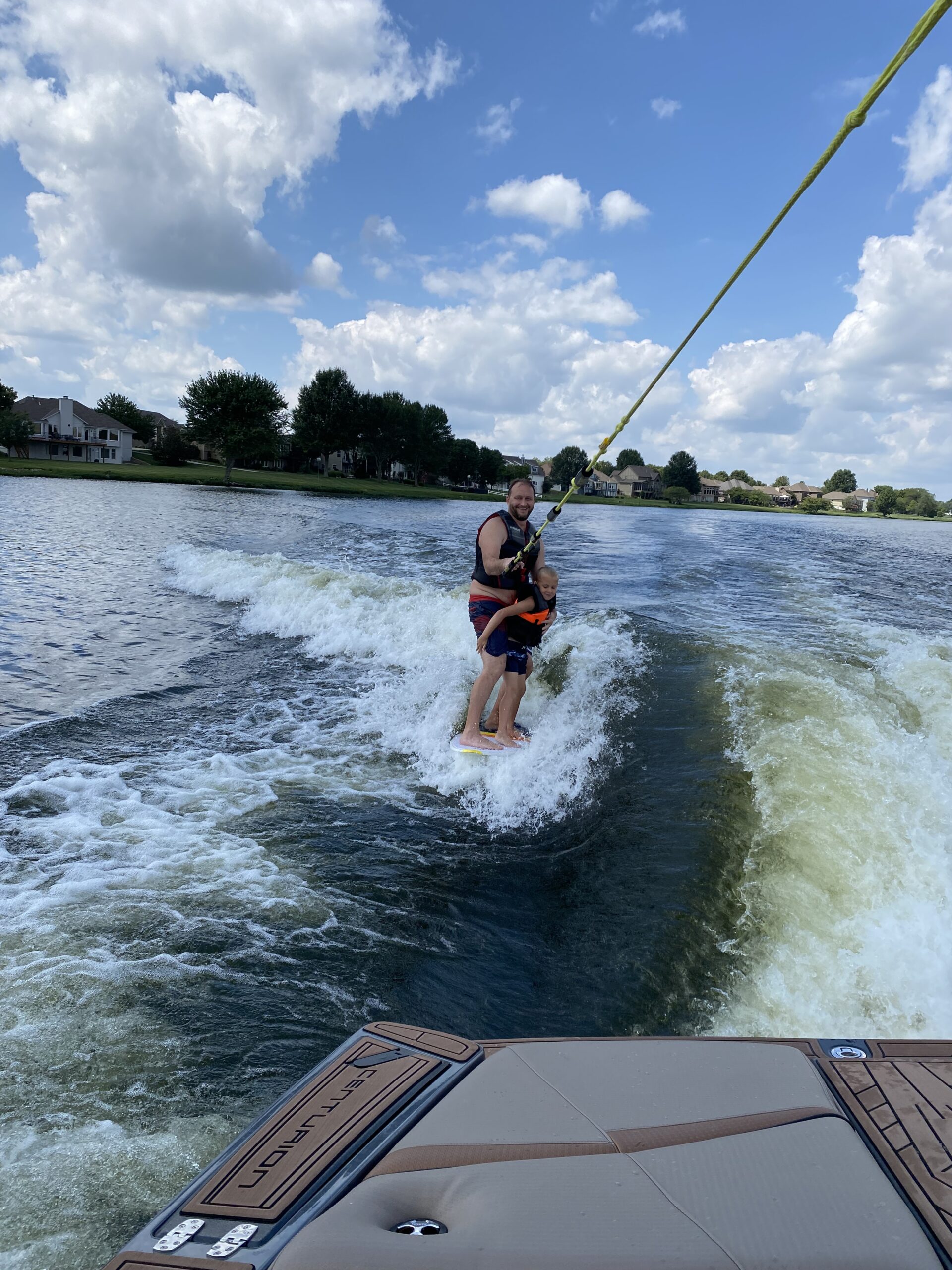 Dad and son wake surfing behind a boat