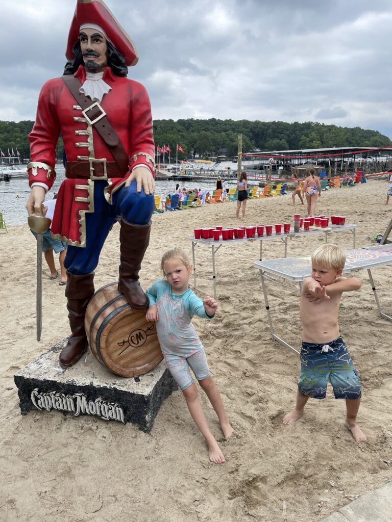 Kids at Captain Rons Bar & Grill on the beach posing with the Captain Morgan statue Lake of the Ozarks