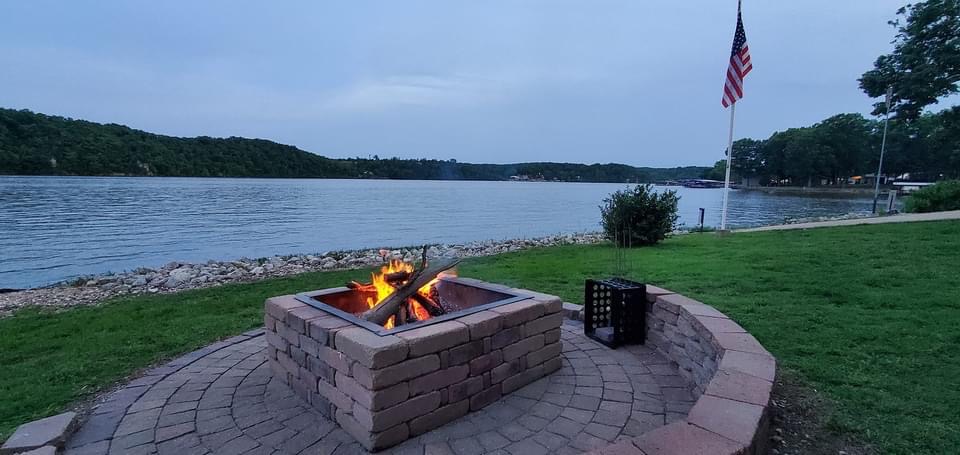 Lakefront at sunset with a Firepit and an American flag in the background