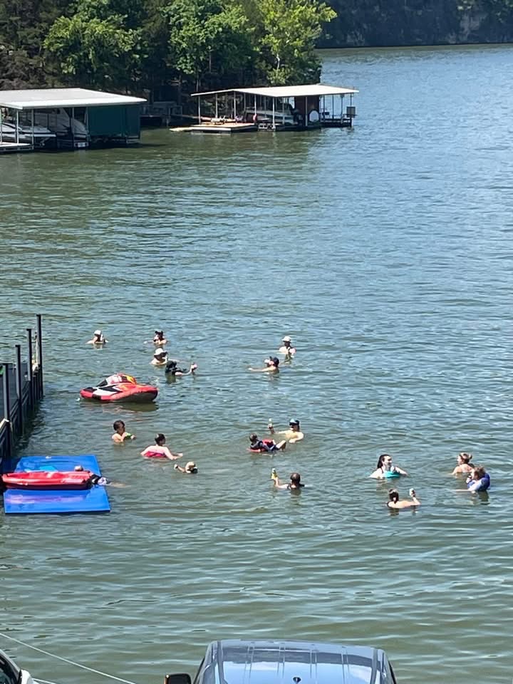 Large Group swimming in the water off the dock at the Lake