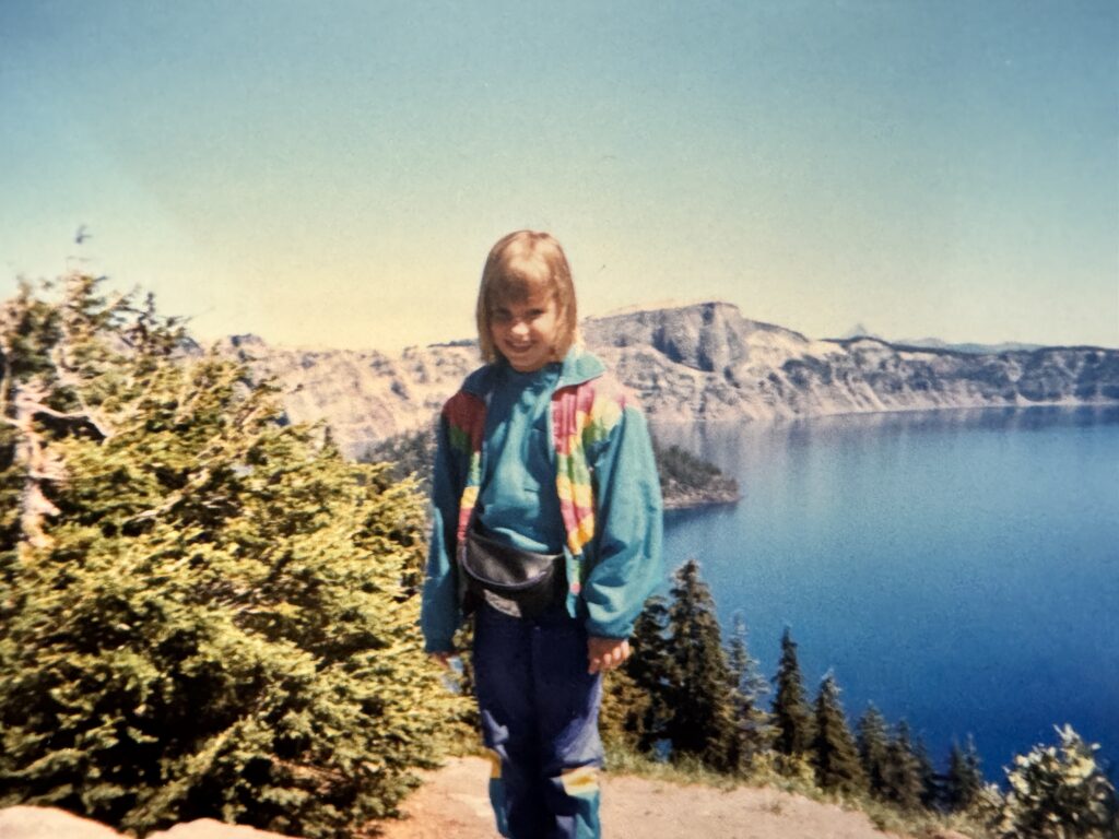 Young girl standing high above Crater Lake (old grainy picture from 1995)