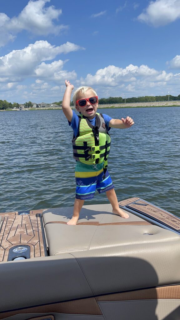 Happy Toddler Dancing on the back of a Boat