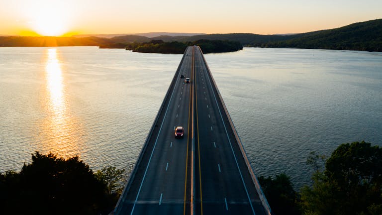 Aerial view of a bridge crossing a lake with cars at sunset in Tennessee.