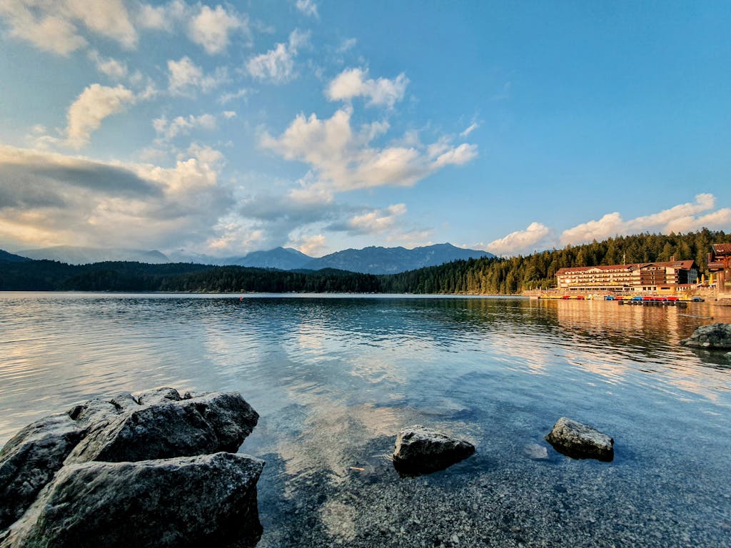 Beautiful view of Eibsee lake with mountains and resort in Grainau, Germany, under a clear sky.