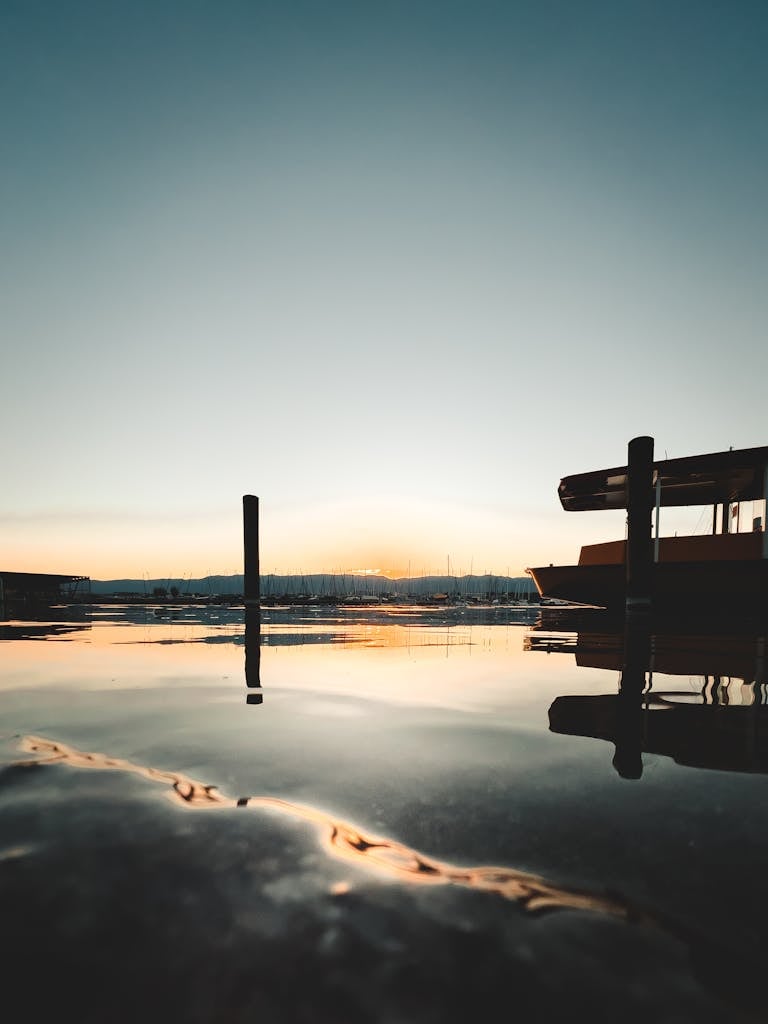 Peaceful sunset view at Lake Geneva, with boats silhouetted against the calm water.