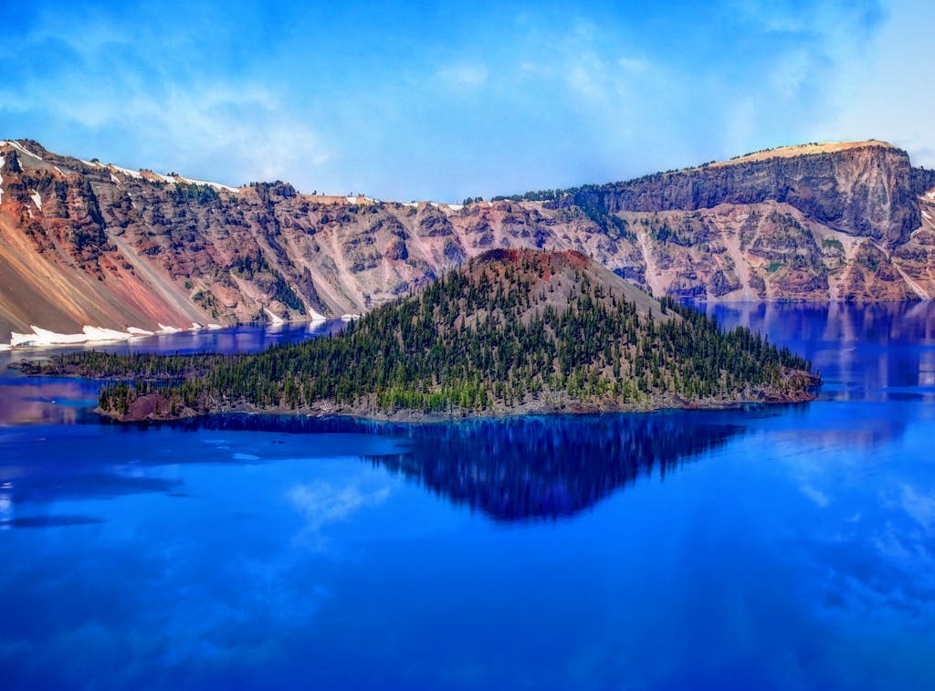 Stunning view of Crater Lake with Wizard Island in Oregon, showcasing the vibrant blue waters and rugged landscape.