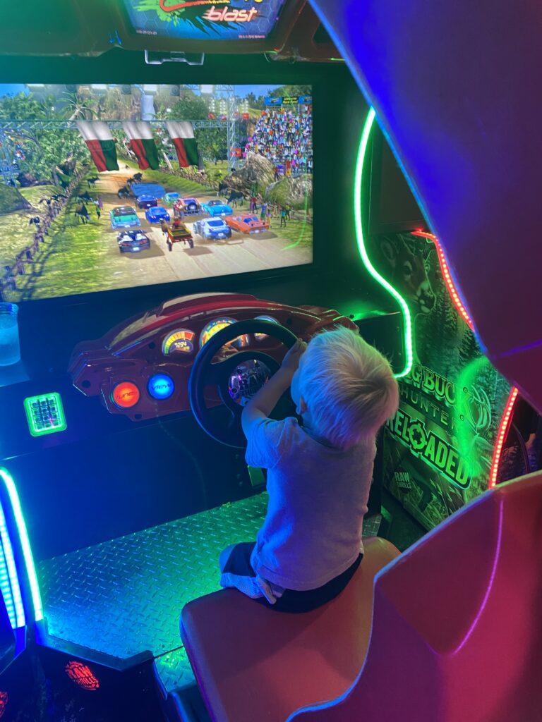 Little kid playing at the arcade at the Anchor at Grand Lake, OK