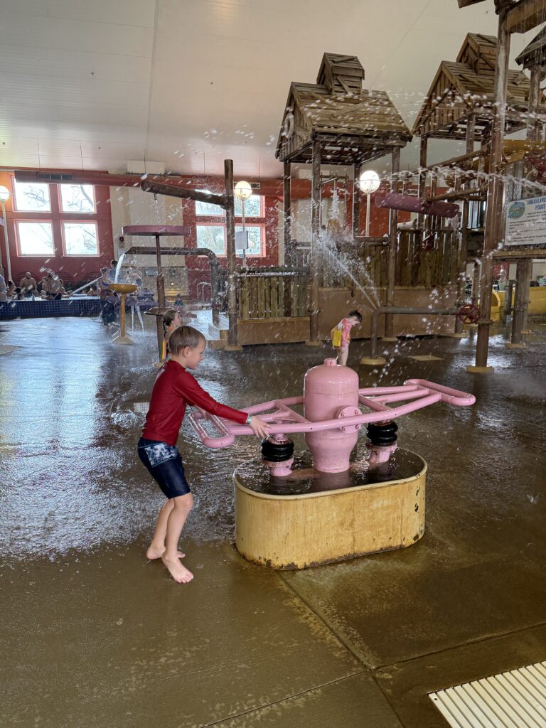 Kid playing with a water shooter at a water park