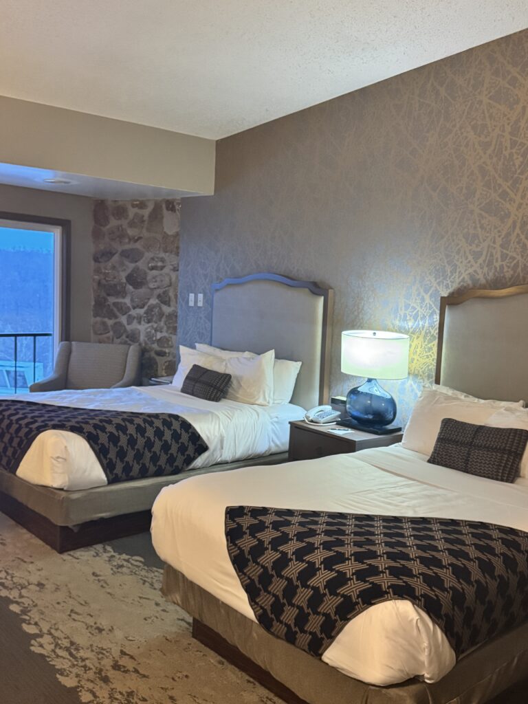 Picture of a hotel room with two beds and a lamp