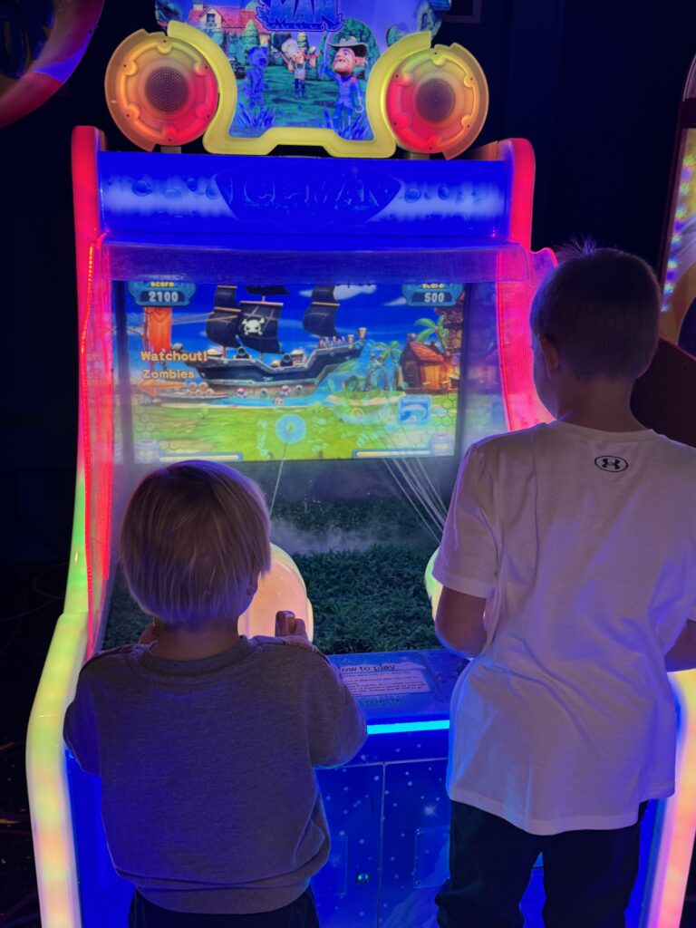 two kids playing a water shooting arcade game