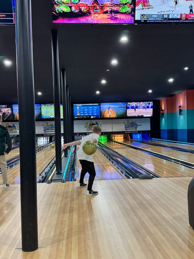 Kid about to throw a bowling ball down the alley