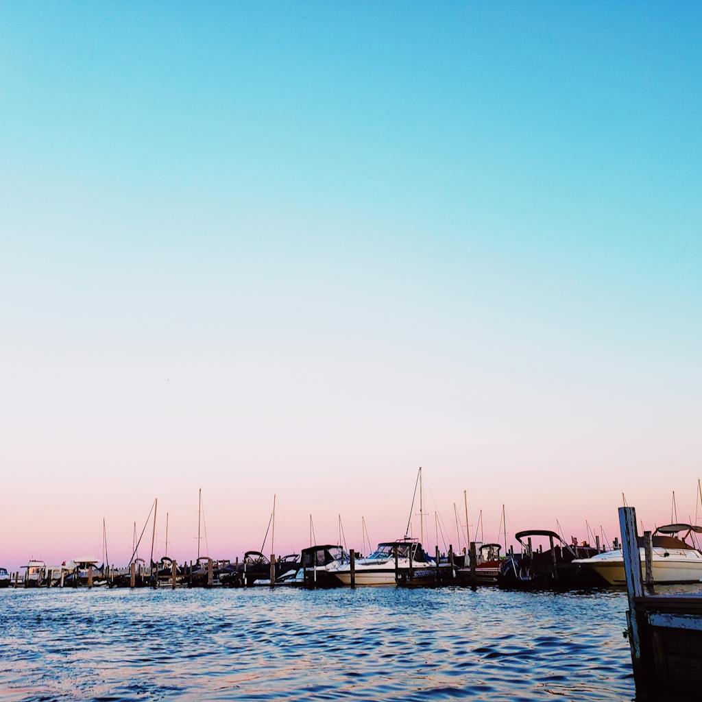 Scenic view of boats docked on a pier with a vibrant twilight sky in Oshkosh.