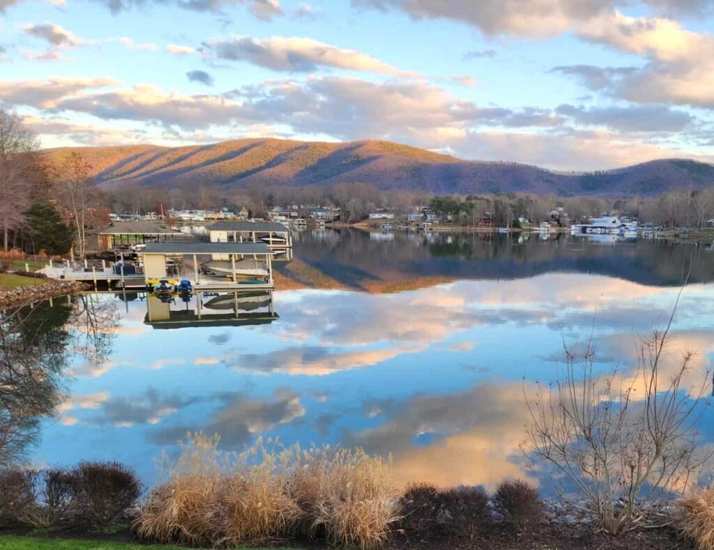 Smith Mountain Lake with clouds reflecting on the water and docks with boats along the shore