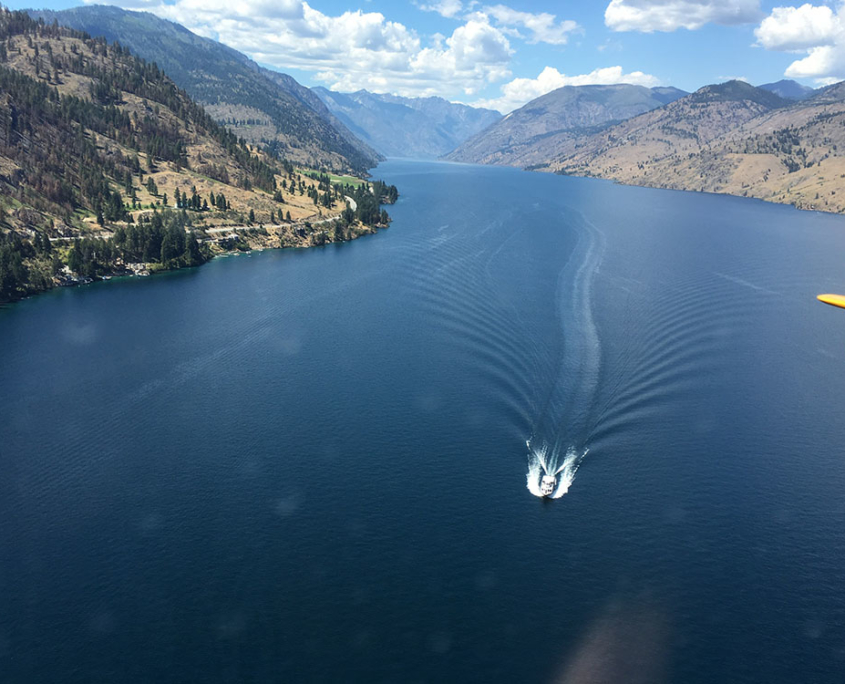 Aerial view of Lake Chelan with a Boat in the distance going across the water