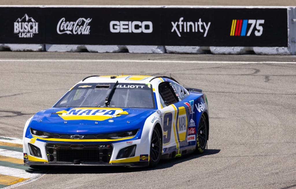 Blue and yellow race car competing on a professional race track.