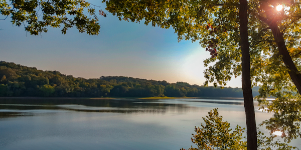 Kentucky Lake with Sun Setting in the background and trees framing the foreground